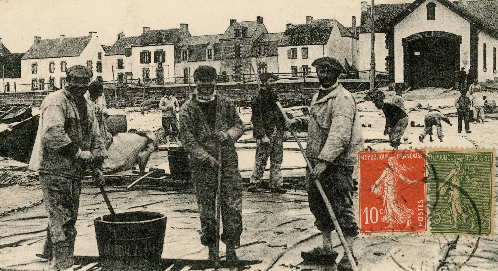 Breton sailors coating boat sails in a fishing port